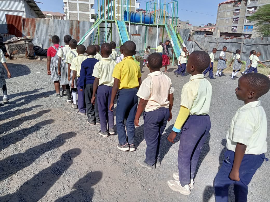 Learners lining up outside near the school playground